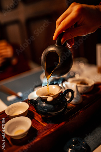 Chinese tea ceremony. Close-up of tea, hand and teapot. Natural light