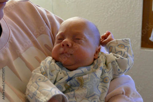 a baby is sleeping in the hands photo