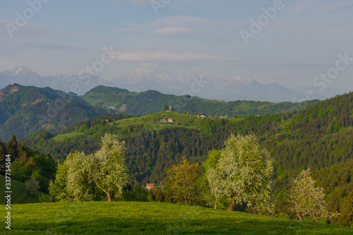 Slovenian breathtaking landscape with Julian Alps and charming little church of Sveti Tomaz (Saint Thomas) on a hill. Beautiful spring in the mountains, in Slovenia.