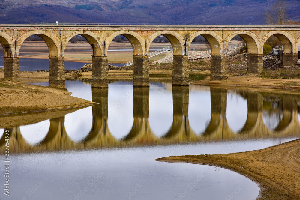 Fototapeta premium lake crossed by a bridge and its reflection
