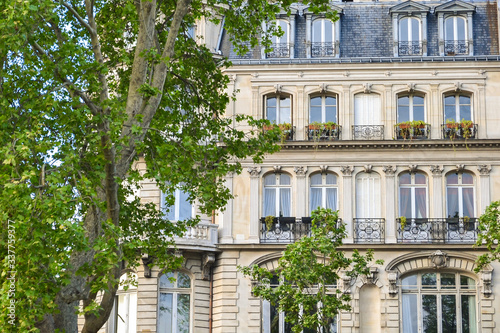 Facade of a house in Paris. The classic building of European architecture. Summer day, sunlight