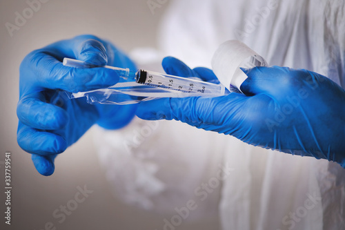 The doctor prepares a single-use sterile medical syringe for the vaccine kit.