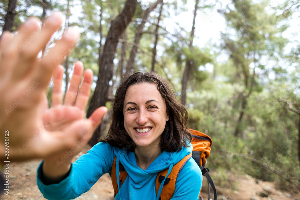 A woman with a backpack gives five to a friend. A woman with a backpack gives five to a friend.