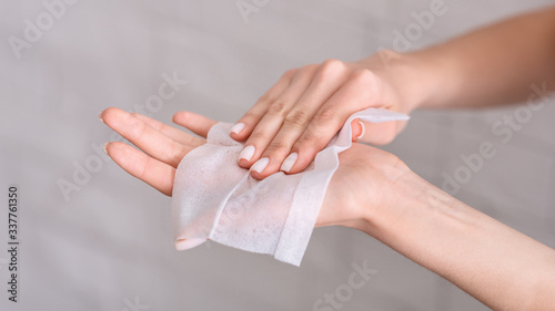 Girl wipes hands with antiseptic napkin, free space