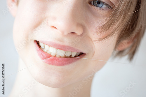 boy flossing his teeth, close-up, life style, oral care and hygiene, teenager brushing his teeth