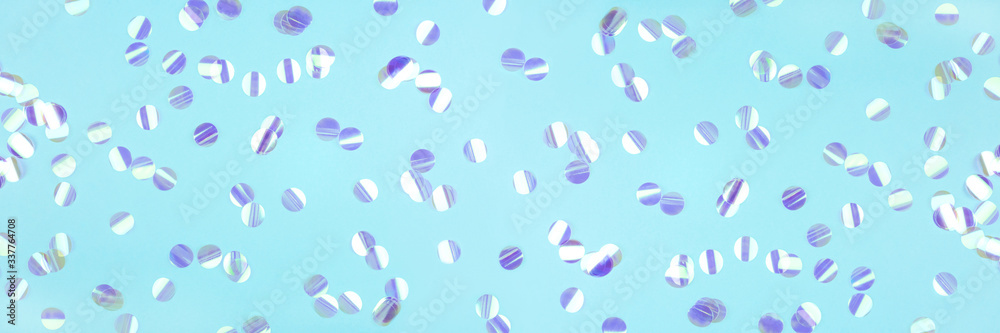 Pearl confetti on blue background. Flat lay, top view.