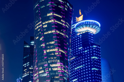 Night view on the centre of the city Doha, Qatar with many modern luxury building and skyscrapers illuminated with numerous lights. Close-up shot