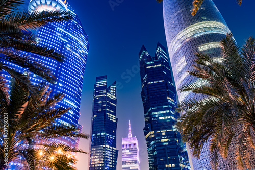 Night view on the centre of the city Doha, Qatar with many modern luxury building and skyscrapers illuminated with numerous lights. Close-up shot