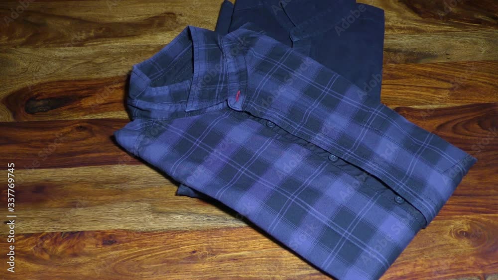 Putting shirts on the table and stacking them on each other Putting shirts on the table and stacking them on each other