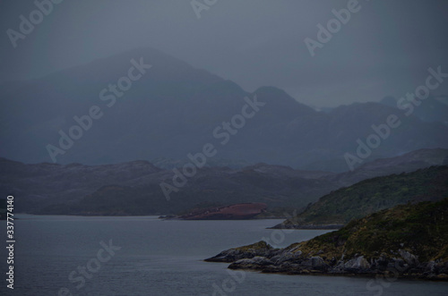 Shipwreck SS Santa Leonor or wreck of sunk ship in Chilean Fjords in Magellan Strait or Beagle Channel in Patagonia bay with mountains in fog or foggy, misty and mystical atmosphere landscape scenery photo