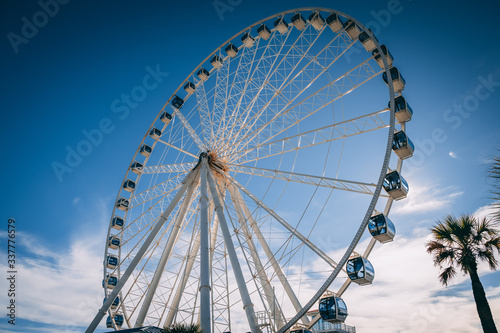 Canvas Print big ferris wheel in front of blue sky with clouds