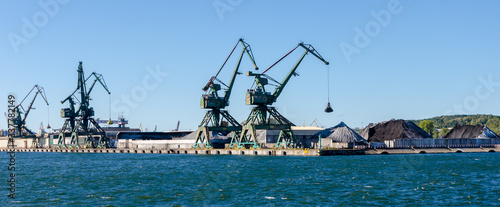 Cranes and piles of coal in a coal port in Gdynia, Poland.