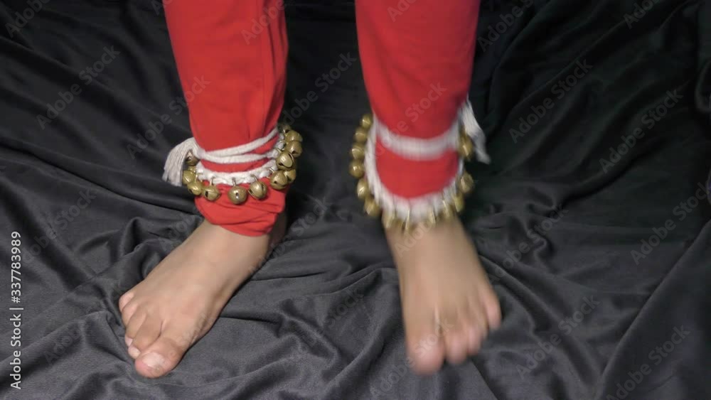 A girl dancing classical dance with Ghunguru tied on her feet.
