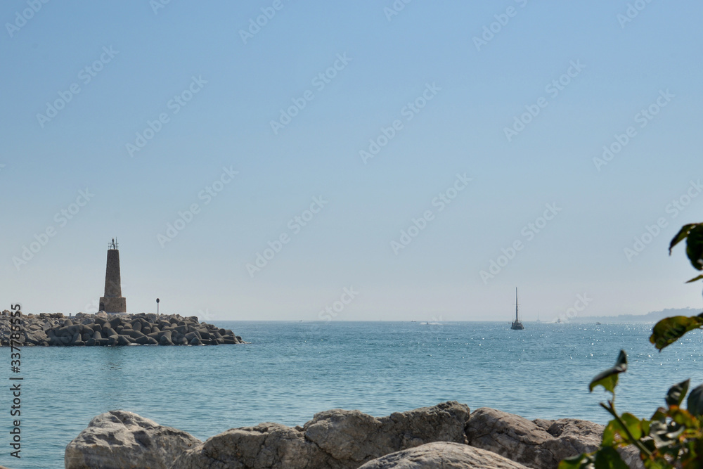 lighthouse on the bay against the sea on a sunny day in summer