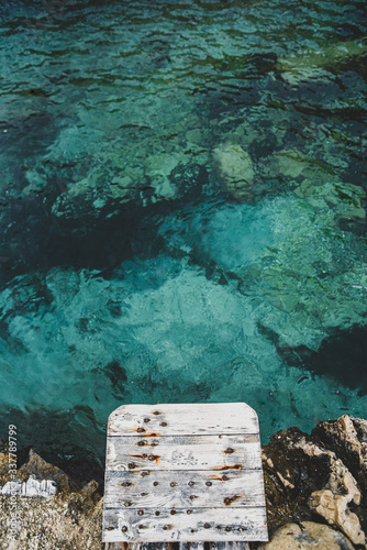 Platform to jump into the water over emerald water.