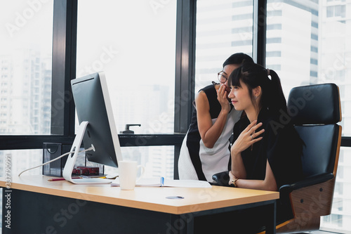 Two young female colleagues reviewing business reports during break in the
