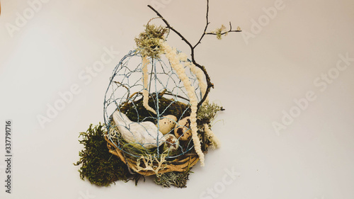 Easter decoration. DIY birdcage with a bird decorated with moss and amaranth.