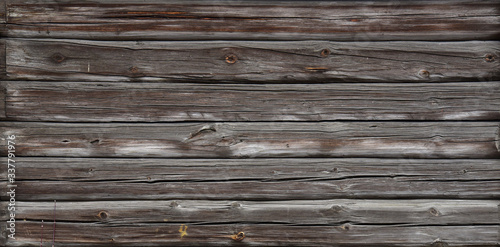 Brown old log wall. Wooden decrepit texture