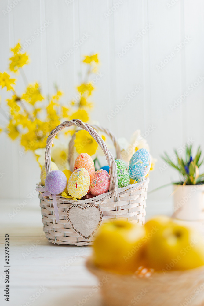 Multi-colored Easter eggs in a basket on a white wooden background Multi-colored Easter eggs in a basket on a white wooden background