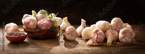 Fresh garlic bulbs with rosemary and pepper photo
