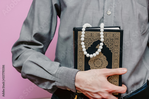 Guy holds Quran and Islamic rosary