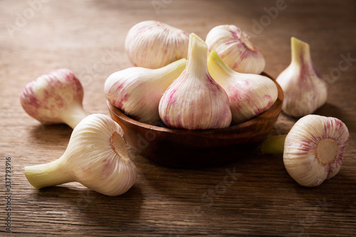 Fresh garlic in a bowl on a wooden table