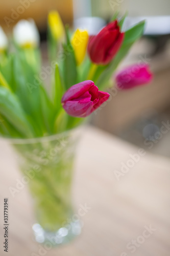 Crystal vase on the table with purple tulips. soft focus, blurred background. close-up