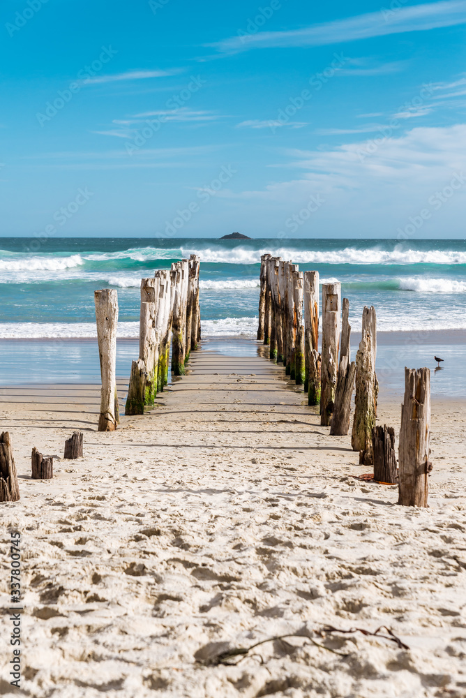 Traditional wooden pole breakwater on an empty beach