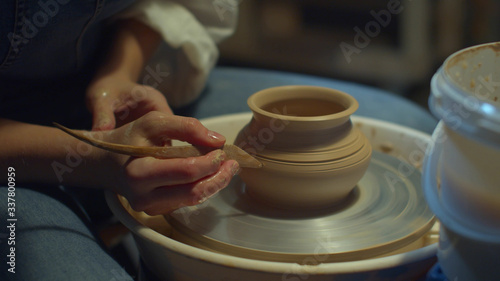 Ceramist carves patterns on a vase. Home hobby