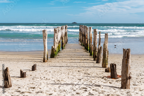 Traditional wooden pole breakwater on an empty beach