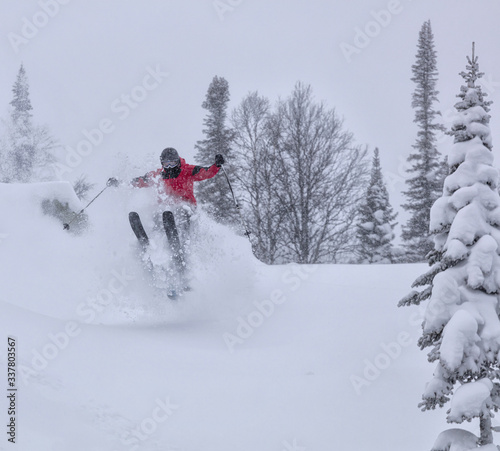 Freerider is buried in fresh snow, turning and jumping between the trees. freeride skiing in deep powder snow. Chest deep snow during snow storm. Good powder day. Funny skiing, rides over off-piste