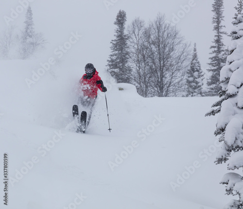 Freerider is buried in fresh snow, turning and jumping between the trees. freeride skiing in deep powder snow. Chest deep snow during snow storm. Good powder day. Funny skiing, rides over off-piste