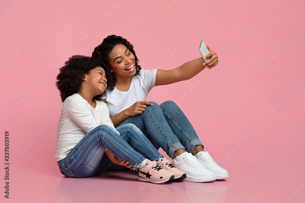 Family Selfie. Cheerful black mother taking photo with her little daughter Family Selfie. Cheerful black mother taking photo with her little daughter