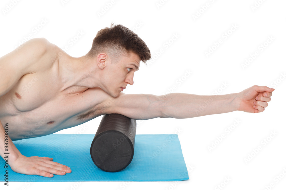 Obraz premium Handsome man shows exercises using a foam roller