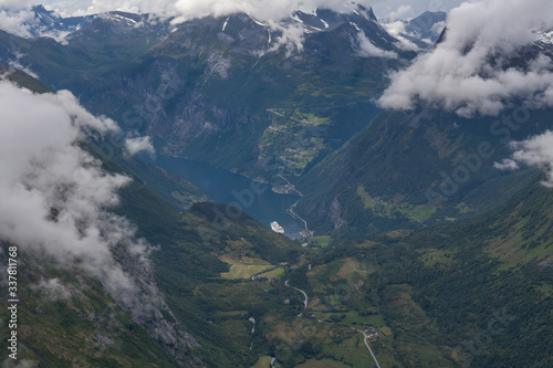 View to Geiranger fjord with cruise ship and eagle road in cloudy weather from Dalsnibba mountain, serpentine road, Norway, selective focus. © Tatiana