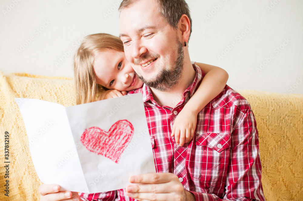 Little girl wishes dad happy father's day. Daughter hugs dad, gives a ...