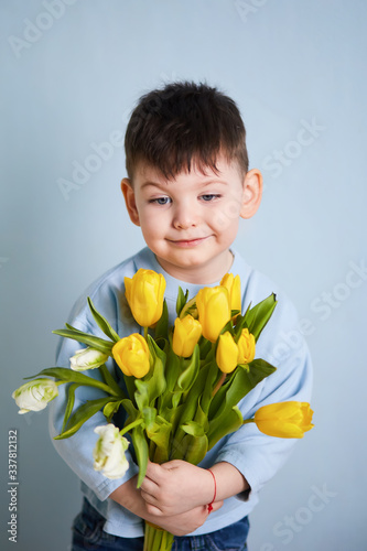 boy with yellow tulips, blue background