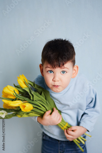 boy with yellow tulips, blue background