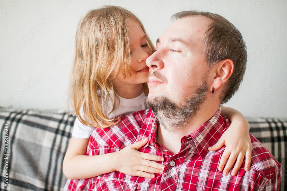 Little girl wishes dad happy father's day. Daughter hugs dad.