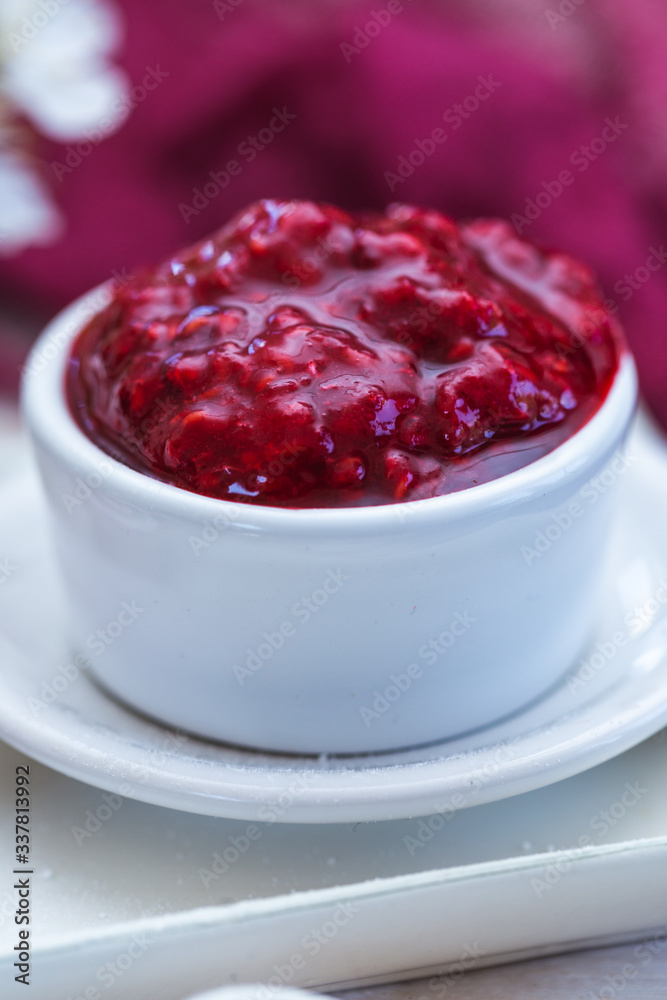 Raw raspberry jam in a white cup with raw raspberry rolls. Vegan food. Raw raspberry jam in a white cup with raw raspberry rolls. Vegan food.
