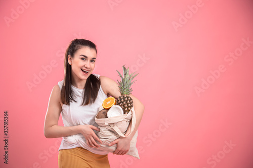 Portrait of a young stylish woman with an eco-fruit bag.