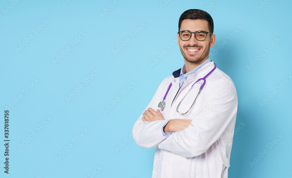Horizontal banner of smiling young doctor ready to help patients with health problems, isolated on blue background with copy space on left Horizontal banner of smiling young doctor ready to help patients with health problems, isolated on blue background with copy space on left