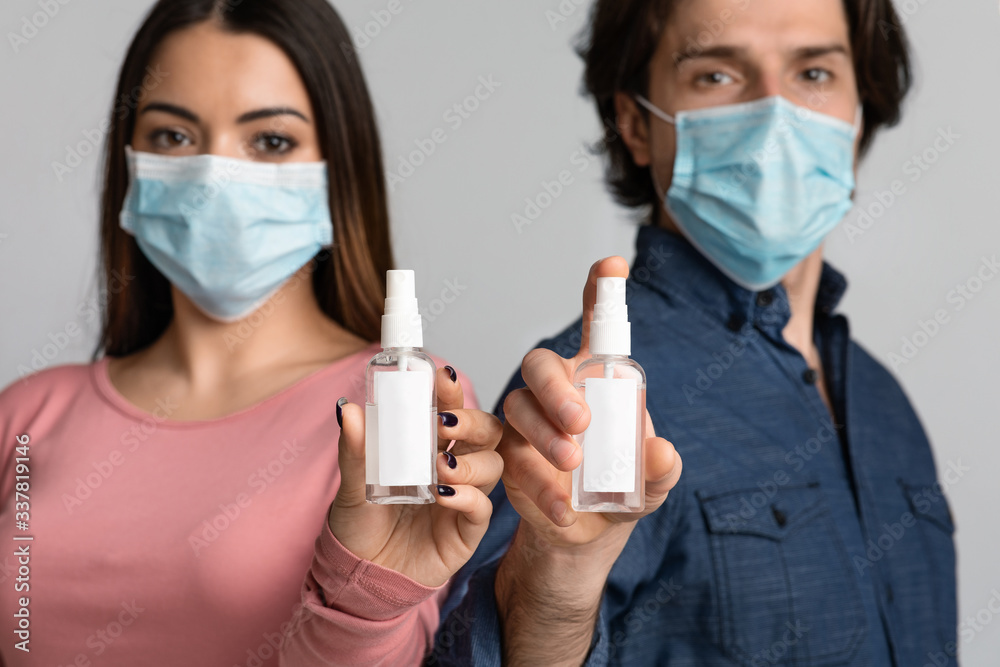 Disinfectant Sprays In Hands Of Young Couple In Medical Masks, Mockup