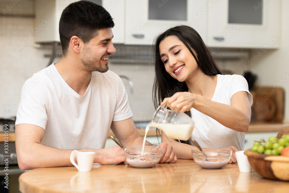 Lovely couple enjoying breakfast muesli with milk Lovely couple enjoying breakfast muesli with milk