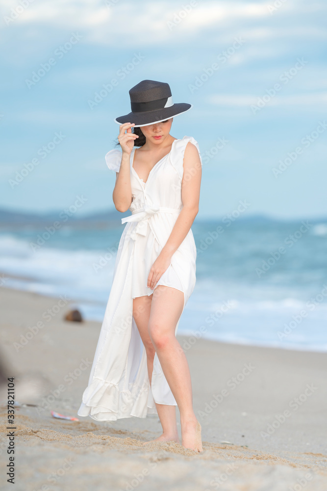 Beautiful women in white dress happily strolling at the beach, beautiful women dressed in white bride Beautiful women in white dress happily strolling at the beach, beautiful women dressed in white bride