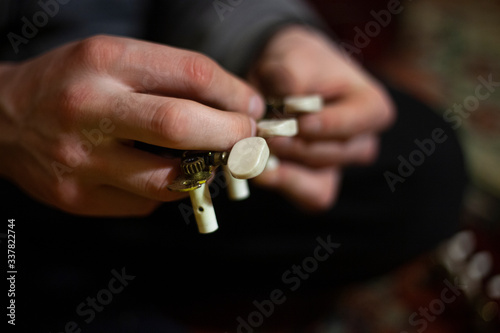 The guy is repairing the guitar.