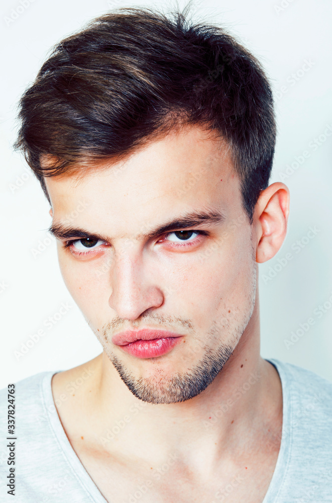 Obraz premium young handsome teenage hipster guy posing emotional, happy smiling against white background isolated, lifestyle people concept close up