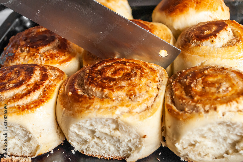 slicing fresh baked sweet breakfast buns slicing fresh baked sweet breakfast buns