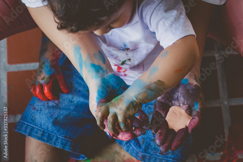 Ensaio fotográfico lifestyle de mãe e filho brincando de forma divertida usando tinta colorida, lembra bastante o que fazer em casa nessa quarentena.