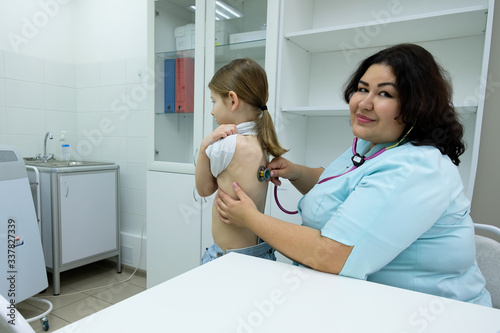 Photos The doctor listens to the patient's heartbeat and breathing with a statoscope in the office